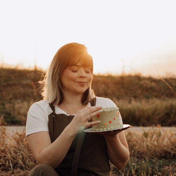 A woman with a relaxed and happy expression enjoying a moment of calm outdoors.