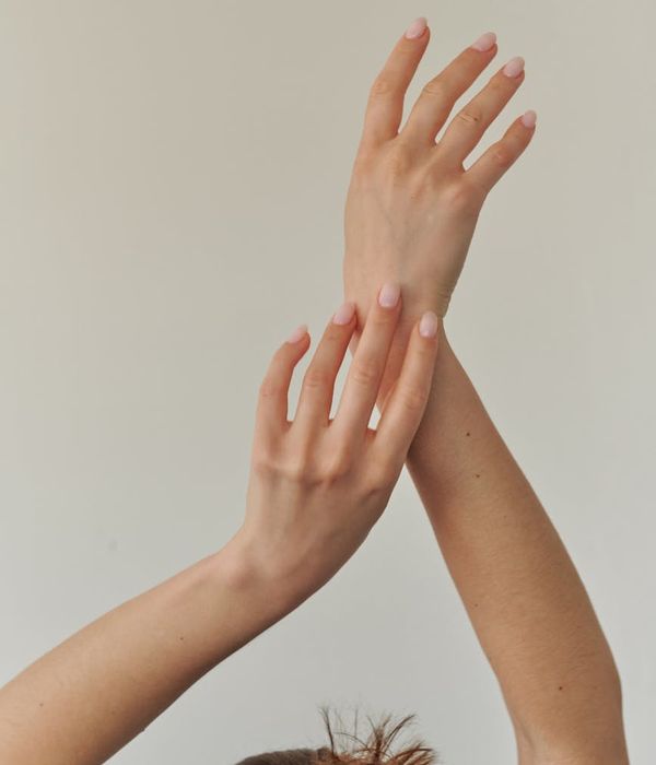 Person doing a gentle stretch in a calm, minimalist space.